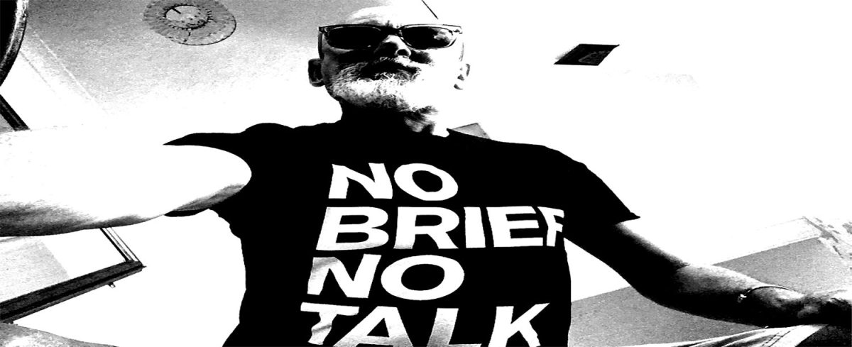 Jonathan Wilcock wearing a T Shirt that says, 'NO BRIEF NO TALK'